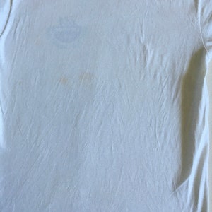May include: A white t-shirt with a few faint yellow stains.