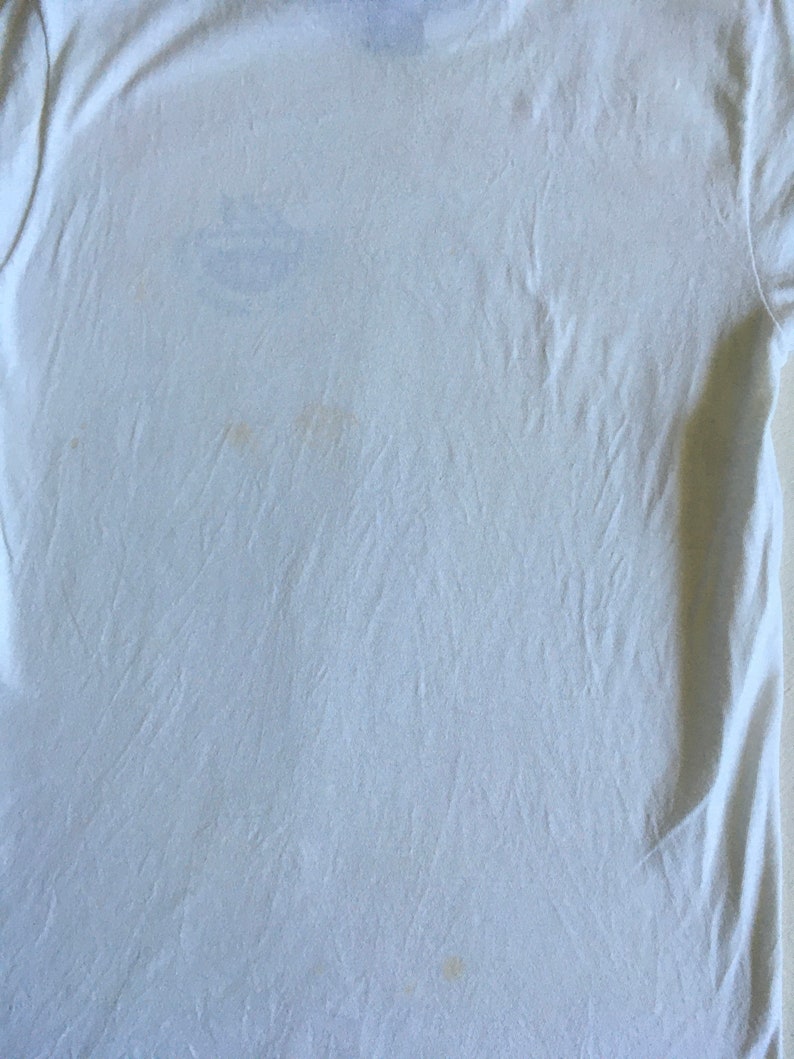 May include: A white t-shirt with a few faint yellow stains.