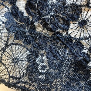 May include: Black lace fabric with a floral pattern. The lace is delicate and intricate, with a fine mesh background.