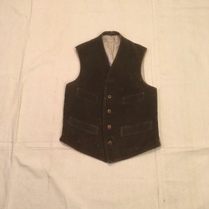 May include: A brown corduroy vest with a button closure and two pockets on each side.