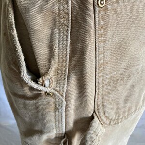 May include: A white ceramic mug with a black handle and the text "But First, Coffee" in a bold, black font. The mug is set against a blurred background, suggesting a cozy setting.