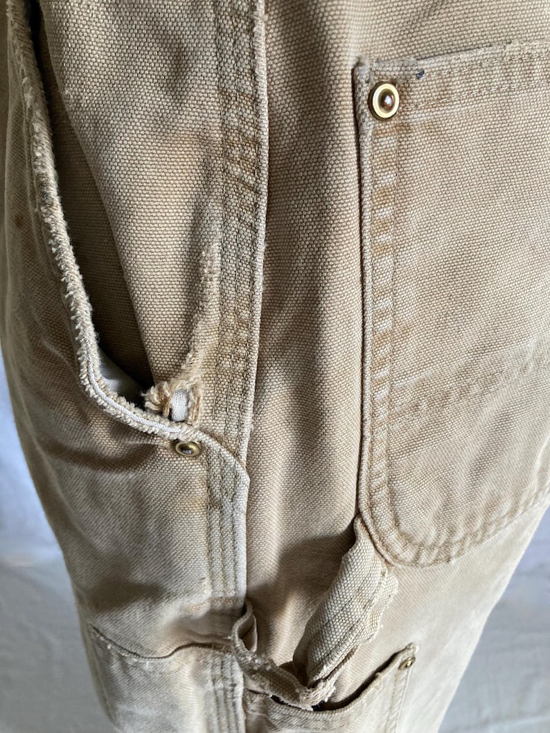 May include: A white ceramic mug with a black handle and the text "But First, Coffee" in a bold, black font. The mug is set against a blurred background, suggesting a cozy setting.