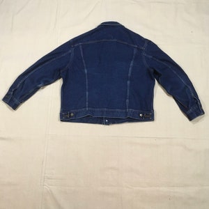 Op de afbeelding: Een donkerblauw denim jack met een knoopsluiting en lange mouwen.