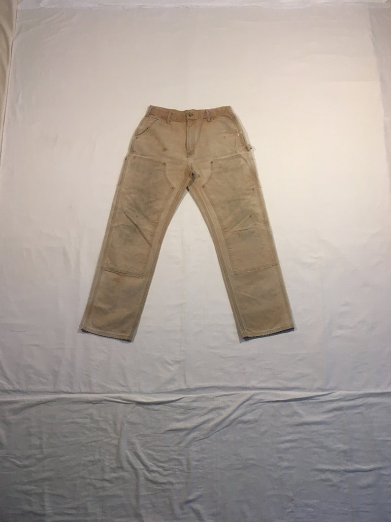 Puede incluir: Un par de pantalones de trabajo de color marr&oacute;n claro con m&uacute;ltiples bolsillos y un aspecto descolorido.