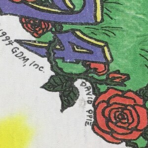 May include: A white t-shirt with a purple, yellow, and green design featuring a rose and the text "&copy; 1994 GDM, Inc. DAVID SPIE"