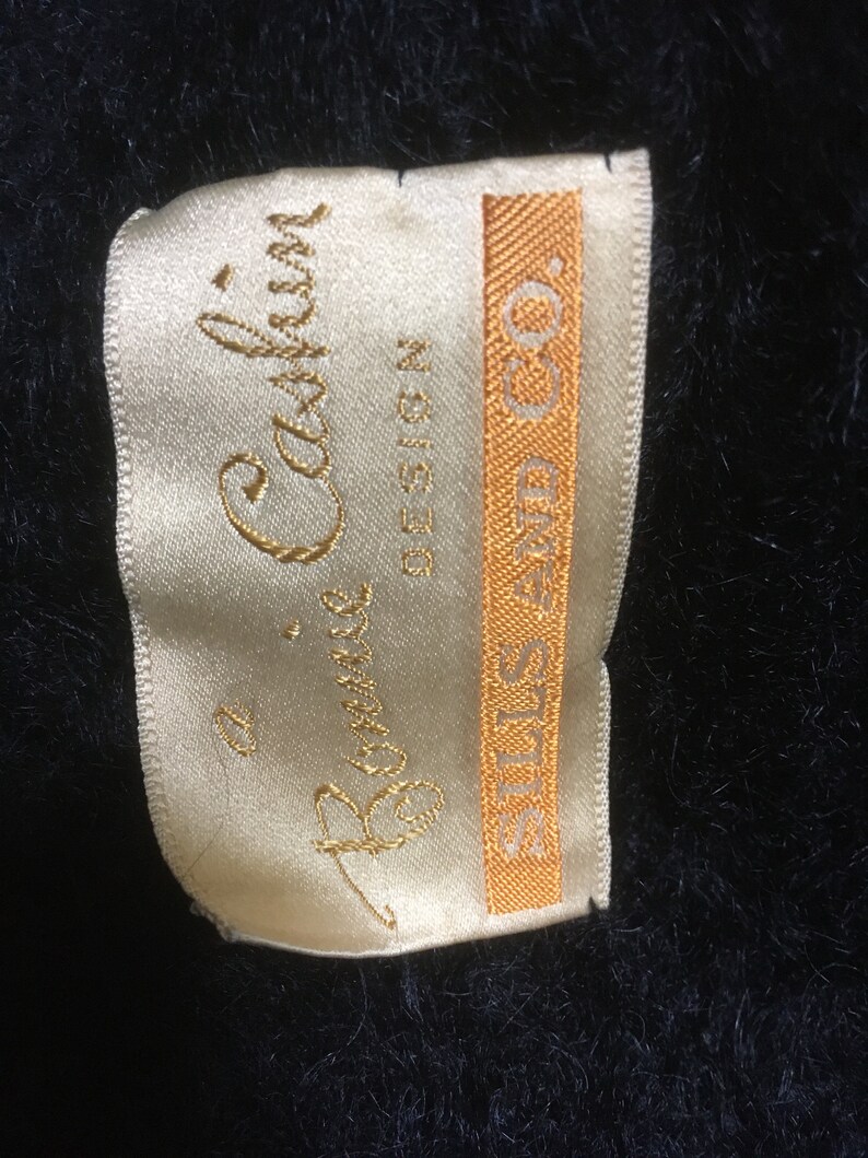 May include: A white satin label with gold lettering that reads "Bonnie Cashin Design" and "STILES-FIND CO."