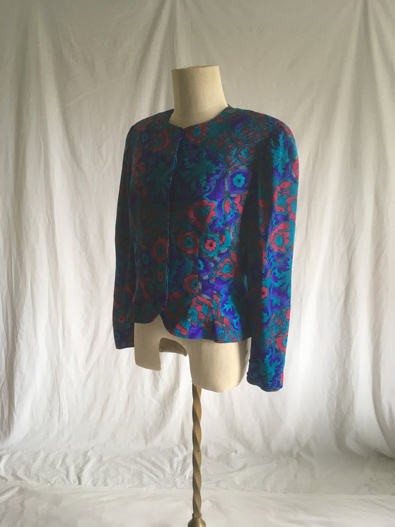 Op de afbeelding: Een teal, paars en roze bloemenprint blazer met lange mouwen en een knoopsluiting.