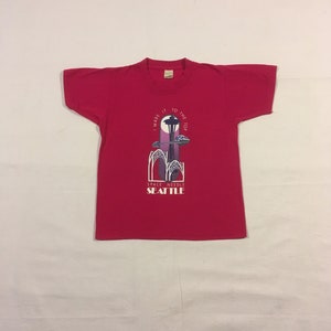 Maglietta rosa vintage per bambini Space Needle Seattle, anni &#39;90, &quot;I made it to the top&quot;, stelle dello schermo, realizzata negli USA, taglia 10-12.
