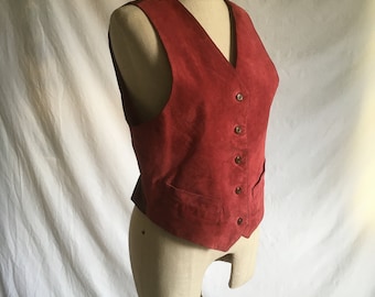 May include: A red suede vest with a V-neck and six buttons down the front.