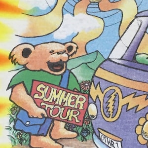 May include: A cartoon illustration of a brown bear holding a red sign that says "Summer Tour". The bear is wearing a green shirt and blue overalls. The bear is standing next to a purple van with a lightning bolt symbol and the text "Othr 1" on the side.