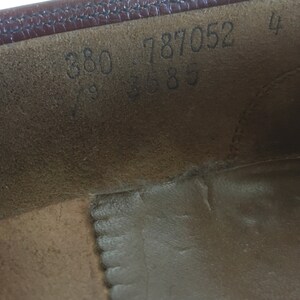 May include: Close-up of the inside of a brown leather shoe with the numbers 380 787052 4 3685 printed on the insole.