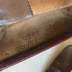 May include: Close-up of the inside of a brown leather shoe with the numbers 380 187092 9996 printed on the insole.