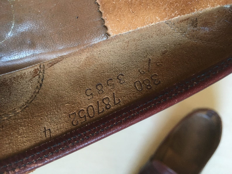 May include: Close-up of the inside of a brown leather shoe with the numbers 380 187092 9996 printed on the insole.