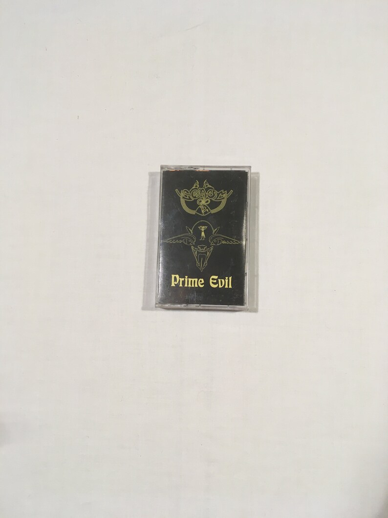 May include: A black cassette tape with a gold design of a winged creature and the text "Prime Evil".