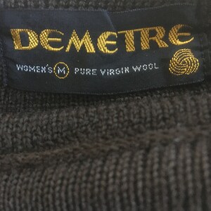 May include: A black label with gold lettering that reads "Demetre" and "Women's M Pure Virgin Wool".