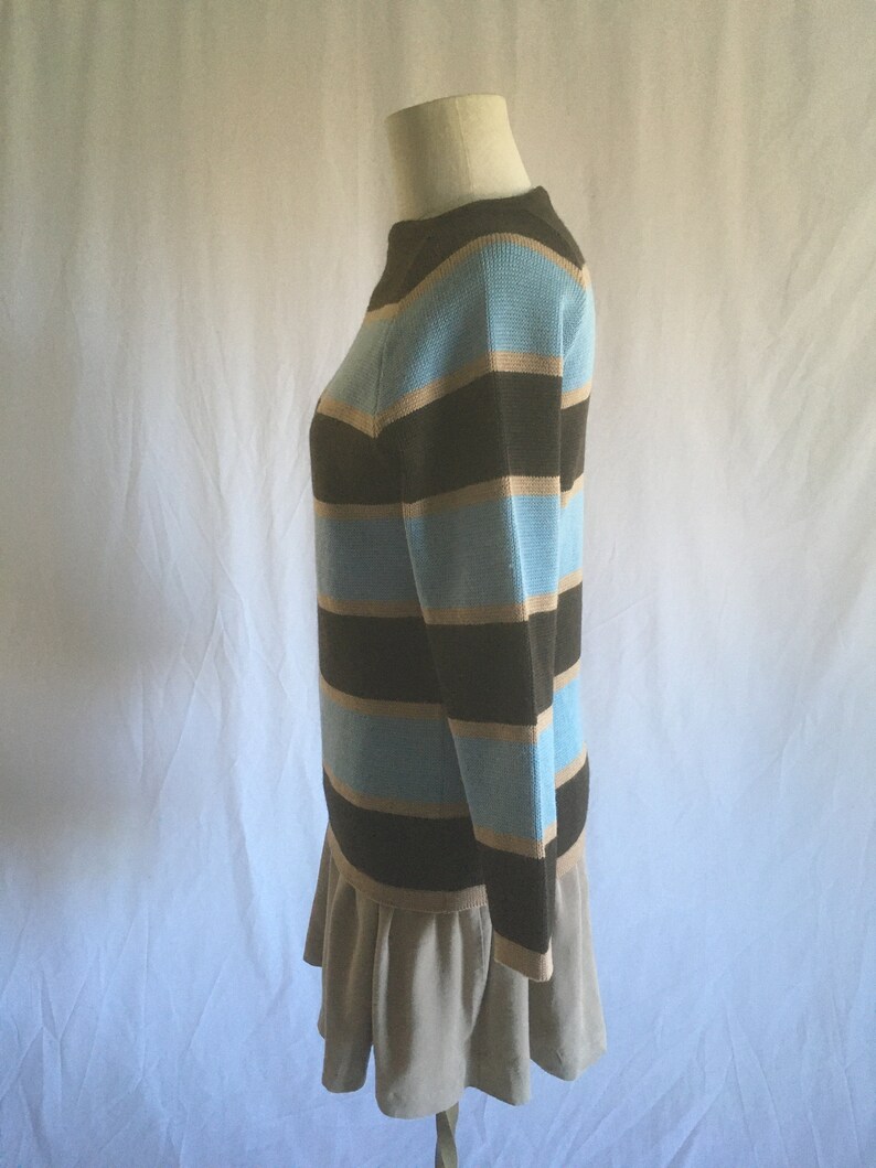 May include: A striped sweater with brown, light blue, and beige stripes. The sweater has long sleeves and a round neckline.