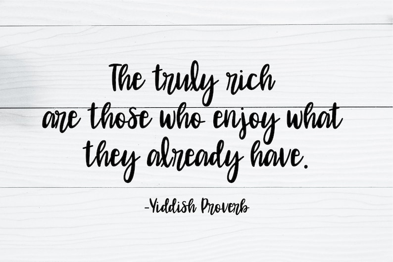 May include: A white wood background with a black text quote that reads "The truly rich are those who enjoy what they already have. -Yiddish Proverb"