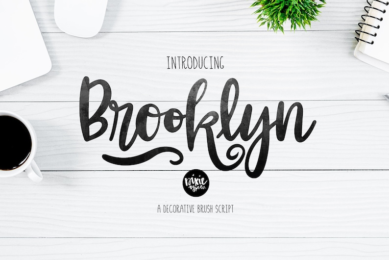 May include: Introducing Brooklyn, a decorative brush script font. The font is shown in black against a white wood background.