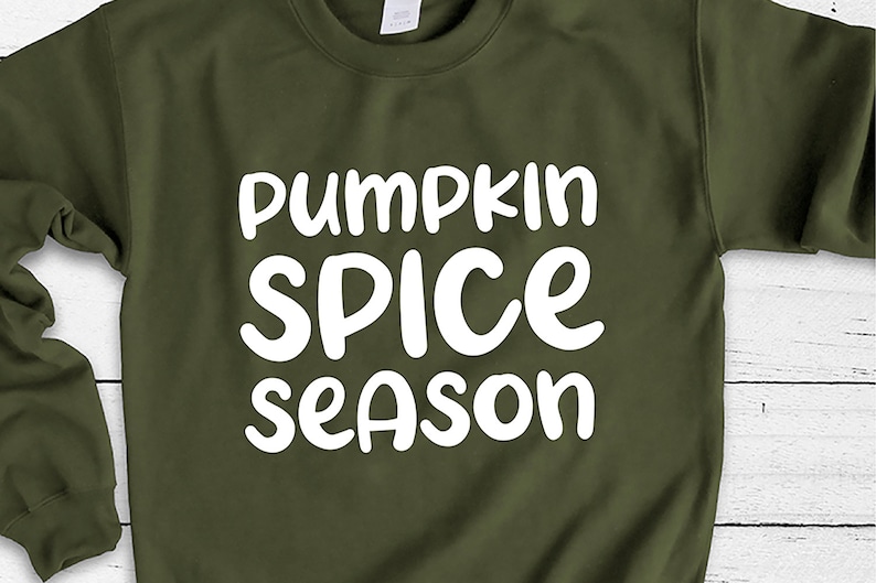 May include: A green sweatshirt with the text "pumpkin spice season" in white lettering.