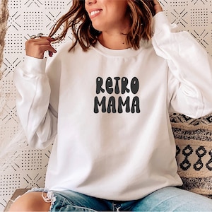 May include: White sweatshirt with the text "Retro Mama" in black, retro-style lettering.