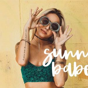May include: A woman wearing round sunglasses, a green crop top, and several bracelets. The text "sunny babe" is written in white cursive letters on a yellow background.