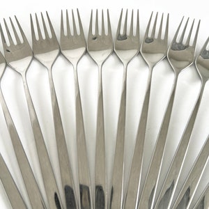 May include: A set of silver forks arranged in a fan shape on a white background.