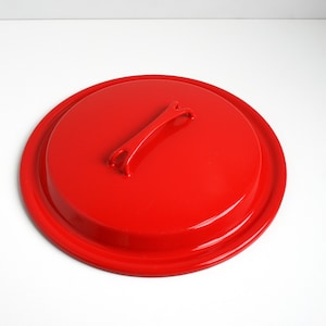 May include: Red enamel pot lid with a metal handle.