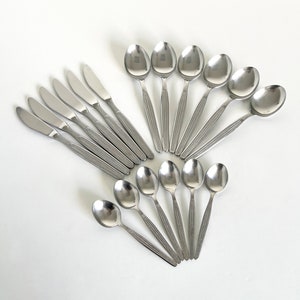 May include: A set of silverware with a textured design. The set includes knives and spoons, all made of stainless steel.