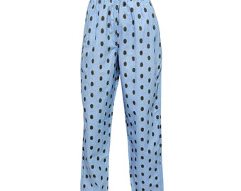 Puede incluir: Pantalones de color azul claro con un estampado integral de pequeños motivos circulares oscuros. La prenda cuenta con una cintura alta con elástico fruncido y un corte de pierna recta que llega hasta los tobillos con un ajuste holgado.