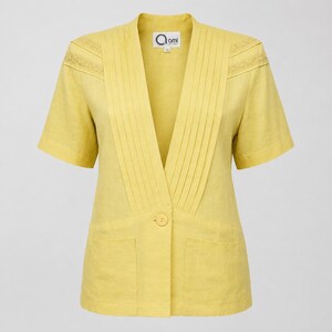 May include: A short-sleeved yellow blazer featuring a deep V-neckline with vertical pleats, two front pockets, and a single button closure. The shoulders are accented with decorative lace trim. The inner label displays the text ami.