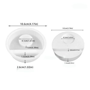 May include: Two white silicone molds for making resin crafts. The larger mold is 10.6 inches wide and 2.6 inches tall. The smaller mold is 9.5 inches wide and 2.4 inches tall. Both molds have a circular opening in the center.