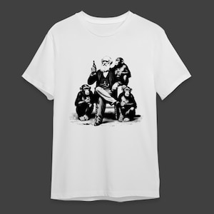 May include: White t-shirt featuring a black and white illustration of a man with a beard and three chimpanzees. The man is seated, holding a bottle, while the chimpanzees hold glasses. The design is a humorous take on a classic portrait.