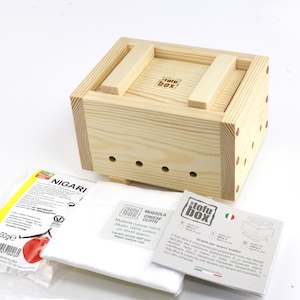 May include: A wooden tofu press kit containing a wooden box, a white cheesecloth, a packet of nigari, and instructions. The box has the text "Tofu Box" printed on it.