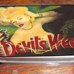 Puede incluir: Una lata metálica rectangular con una ilustración vintage. La obra de arte presenta a una mujer rubia, una criatura verde y el texto "The Devil's Weed" en rojo. El diseño general tiene un estilo retro, pulp-art.