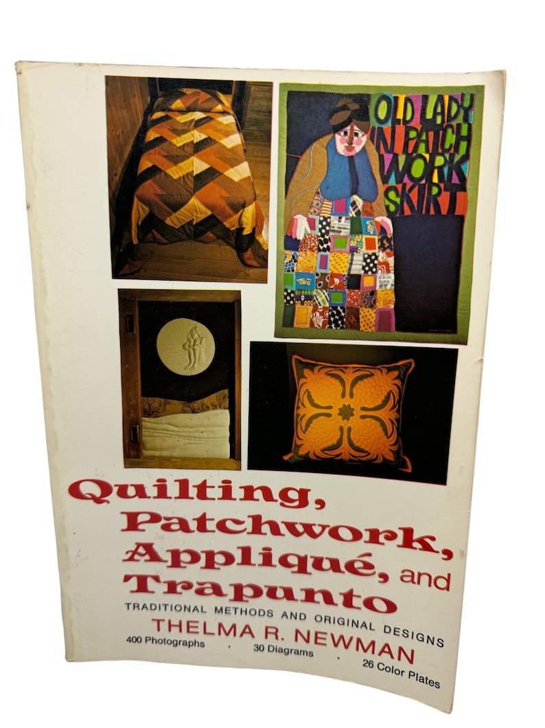 May include: Book cover with the title "Quilting, Patchwork, Appliqu&eacute;, and Trapunto" by Thelma R. Newman. The cover features four colorful quilt designs, including a patchwork skirt with the text "Old Lady in Patch Work Skirt".