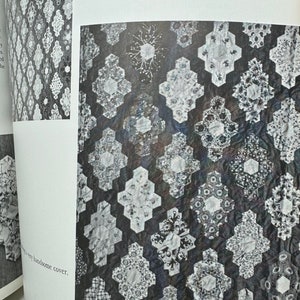 May include: A black and white quilt with a geometric pattern. The quilt is made up of many small squares and triangles, and it has a very intricate design. The overall pattern takes a very long time to make.