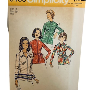 Puede incluir: Patrón de costura Simplicity número 6466 para una blusa de mujer. El patrón incluye tres estilos diferentes: una blusa de rayas verdes, una blusa floral roja y una blusa de lunares blancos con un estampado de borde. El patrón es para las tallas 14 y una talla de pecho de 91 cm.