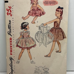May include: Vintage Simplicity sewing pattern for a girl's dress. The pattern is for size 4 and costs 35 cents. The pattern shows three different styles of dresses, all with a gingham print.