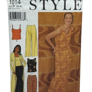 Op de afbeelding: Een vintage naaipatroon met de titel "STYLE" en het nummer 1014. Het patroon bevat illustraties van verschillende outfits, waaronder een jurk, top, broek en rok. De maten variëren van XS tot XL.