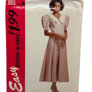 Könnte beinhalten: Vintage Schnittmuster mit einer Frau in einem rosa Polka-Dot-Kleid mit weißem Kragen und Puffärmeln. Das Muster ist mit "Easy Stitch 'N Save" von McCall's gekennzeichnet, mit der Nummer 6913 und der Größe B.