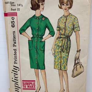 Könnte beinhalten: Vintage Simplicity Schnittmuster Nummer 4559 für ein Halbgrossen-Slenderette-Kleid. Das Schnittmuster enthält Anleitungen für zwei verschiedene Kleidstyles, eines in Grün und eines in einem Blumendruck. Das Schnittmuster ist für Grösse 14 1/2 mit einem Brustumfang von 89 cm.