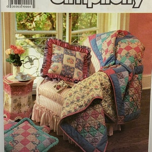 May include: Simplicity pattern for a quilted throw, cushion, and seat pad. The design features a floral patchwork pattern. The word "Simplicity" is at the top. The pattern is labelled "7139" and "ONE SIZE".