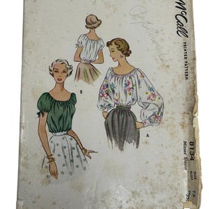 May include: Vintage McCall's printed pattern for Misses' Blouse, size 16, featuring illustrations of blouses with different sleeve and neckline styles. The cover is aged with wear and tear, showing a faded color palette.