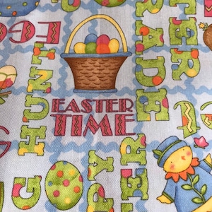 Può includere: Un tessuto blu con un motivo ripetuto di parole e immagini a tema pasquale. Le parole "Easter Time" sono in rosa e bianco. Ci sono immagini di uova, cesti e un pulcino.