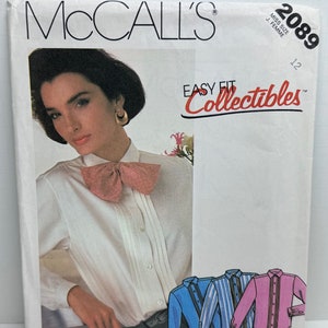May include: McCall's Easy Fit Collectibles sewing pattern number 2089 size 12 for a white blouse with a bow tie. The pattern includes instructions for making three different blouses: a solid white blouse, a blue and white striped blouse, and a pink blouse.