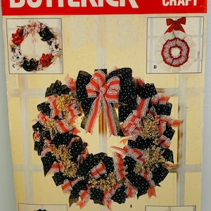 May include: A vintage craft pattern from Butterick, pattern number 4074, for making wreaths. The pattern shows five different wreath designs, including a red, white, and blue wreath with black polka dots, a wreath with white lace and red bows, and a wreath with purple flowers.