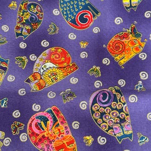 May include: A purple fabric featuring a repeating pattern of colourful, stylised cats and butterflies. The cats have detailed designs, and the butterflies are scattered across the background. White spiral shapes are also present.