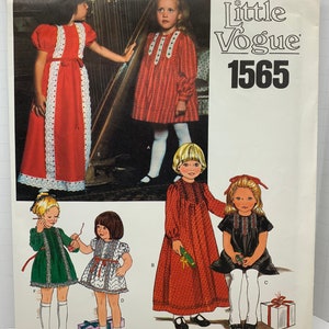 Może przedstawiać: Wzór szycia Little Vogue numer 1565 na sukienki dla dziewczynek. Wzór zawiera pięć różnych stylów sukienek, z opcjami na długie i krótkie rękawy oraz różnorodne tkaniny. Sukienki są pokazane w kolorze czerwonym, zielonym, czarnym i białym.