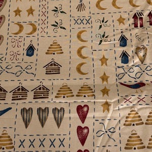Könnte beinhalten: Cremefarbener Stoff mit einem sich wiederholenden Muster verschiedener Motive zum Thema Landhausstil. Das Design umfasst Sterne, Monde, Herzen, Vogelhäuser, Bienenkörbe, Vögel und Schleifen, alles in Braun-, Blau- und Rottönen. Das Muster ist in einem Raster mit gestrichelten Linien angeordnet.