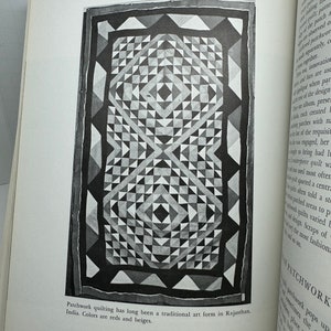 May include: A black and white patchwork quilt with a geometric pattern. The quilt is made of squares and triangles. The text "Patchwork quilting has long been a traditional art form in Rajasthan, India. Colors are reds and beiges." is printed below the quilt.